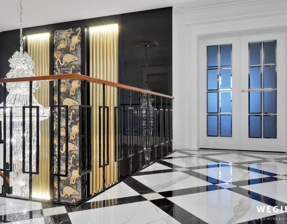 Wyrafinowany projekt architekta wnętrz domów tym razem dotyczy klatki schodowej. To odważne połączenie tapety w złote flamingi, marmurów i kryształów.